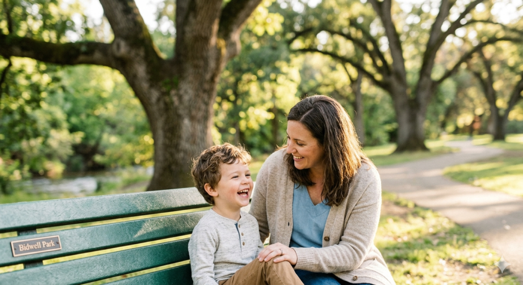 A parent and child sharing a happy moment in a Chico park, symbolizing the primary goal of child custody cases: protecting the child’s well-being.